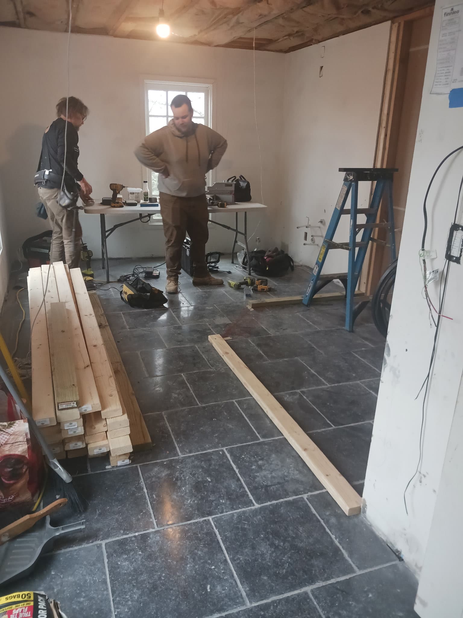 Trades working in a room during sauna installation.